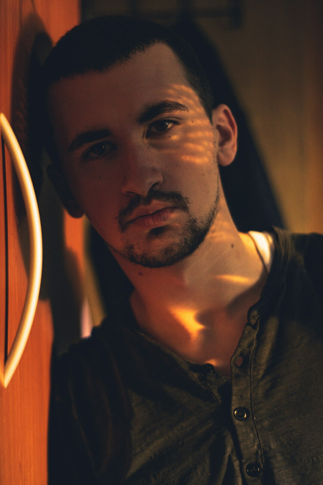 Studio portrait of a white man in his late twenties with short beard wearing a shirt